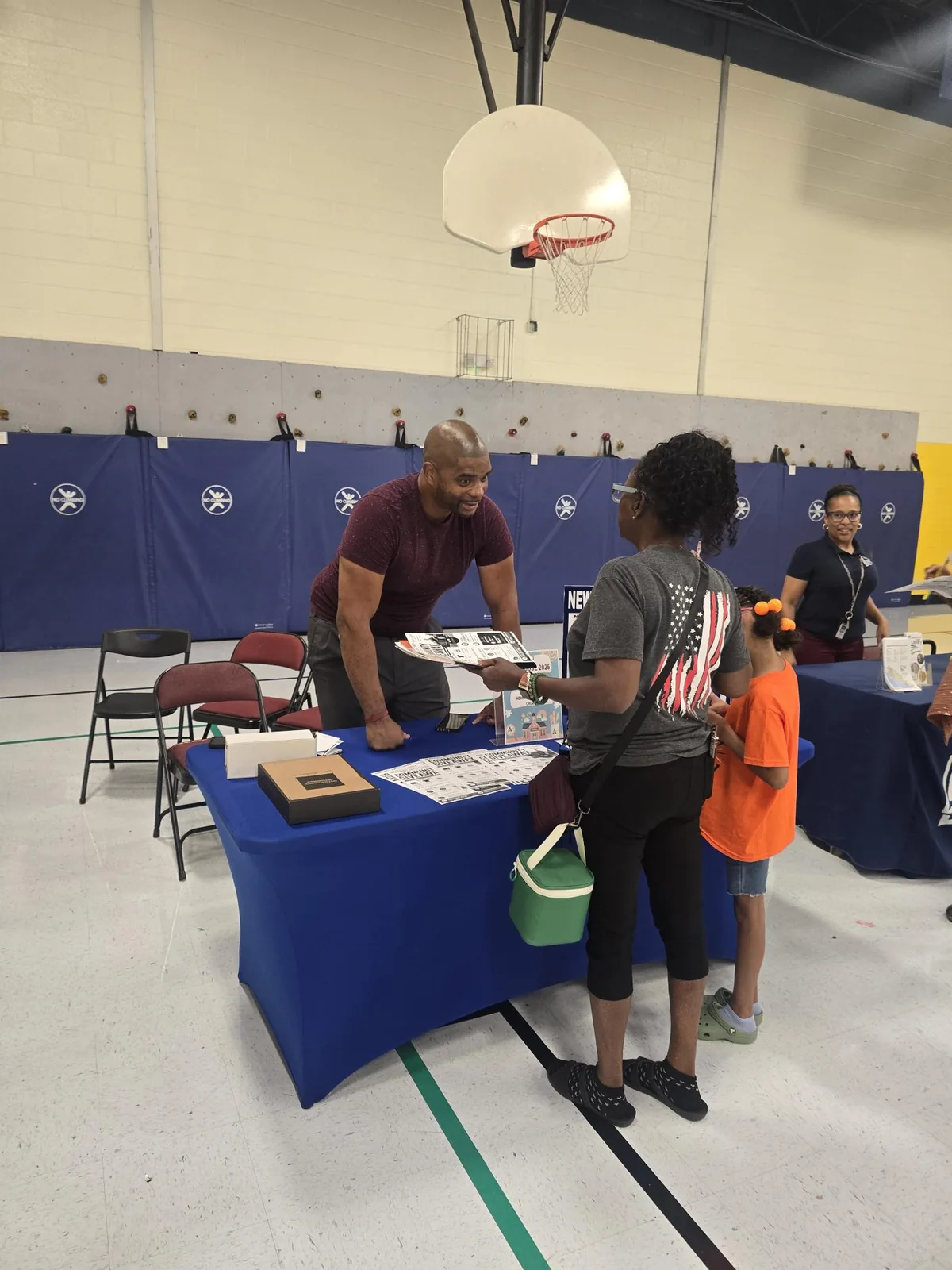 A Foundations To Success representative speaking directly with a family at the Achievable Dreams community event