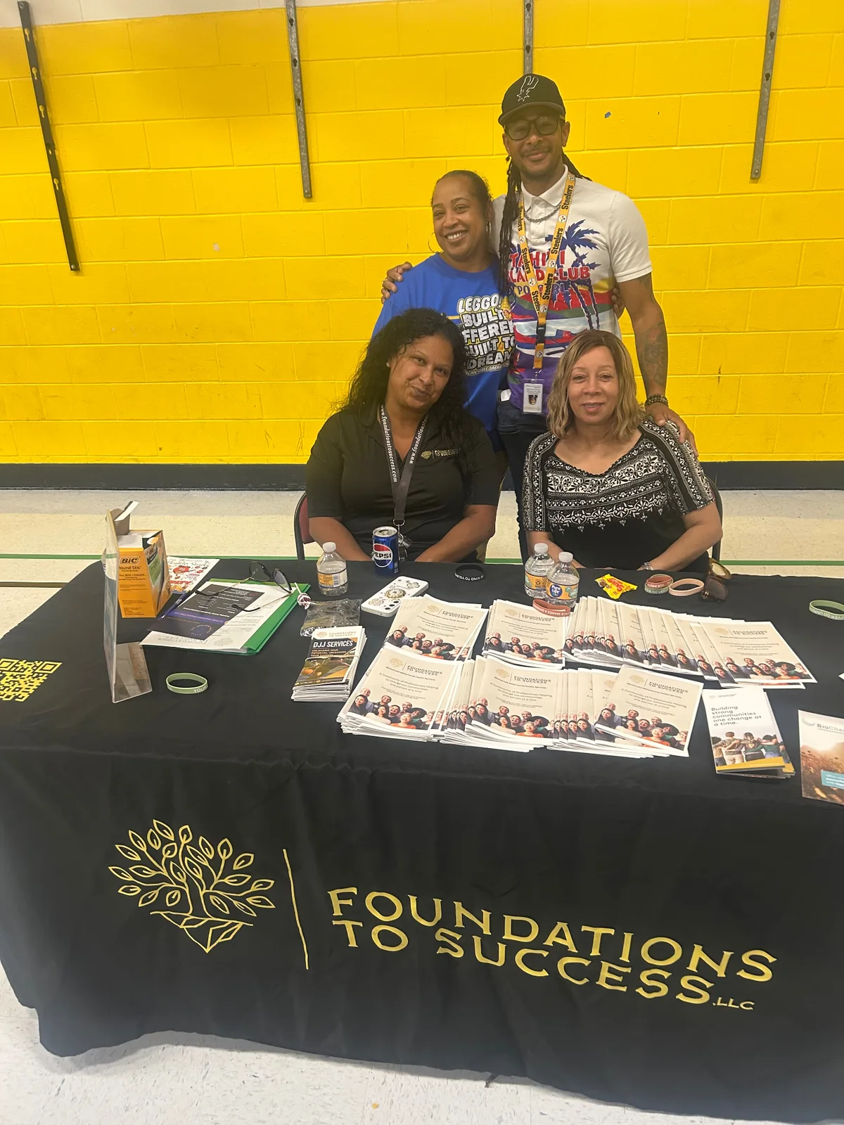 Foundations To Success team members at the full branded community resource table during an Achievable Dreams family event